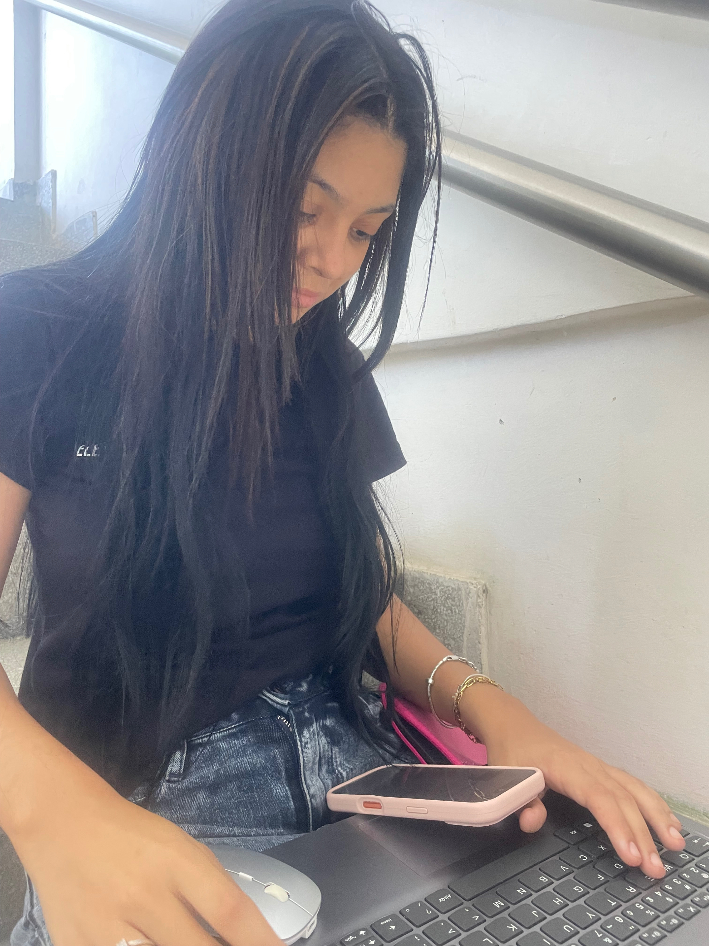 Ela concentrada no notebook, com o cabelo solto caindo no rosto.