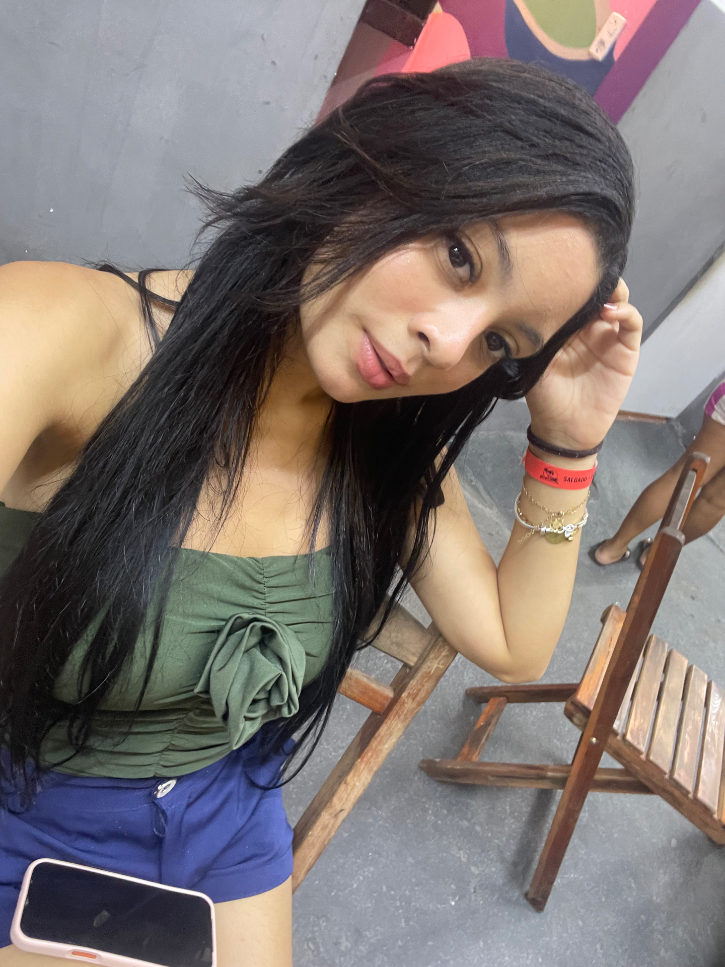 Selfie com blusa verde e cabelo solto, em um momento espontâneo.